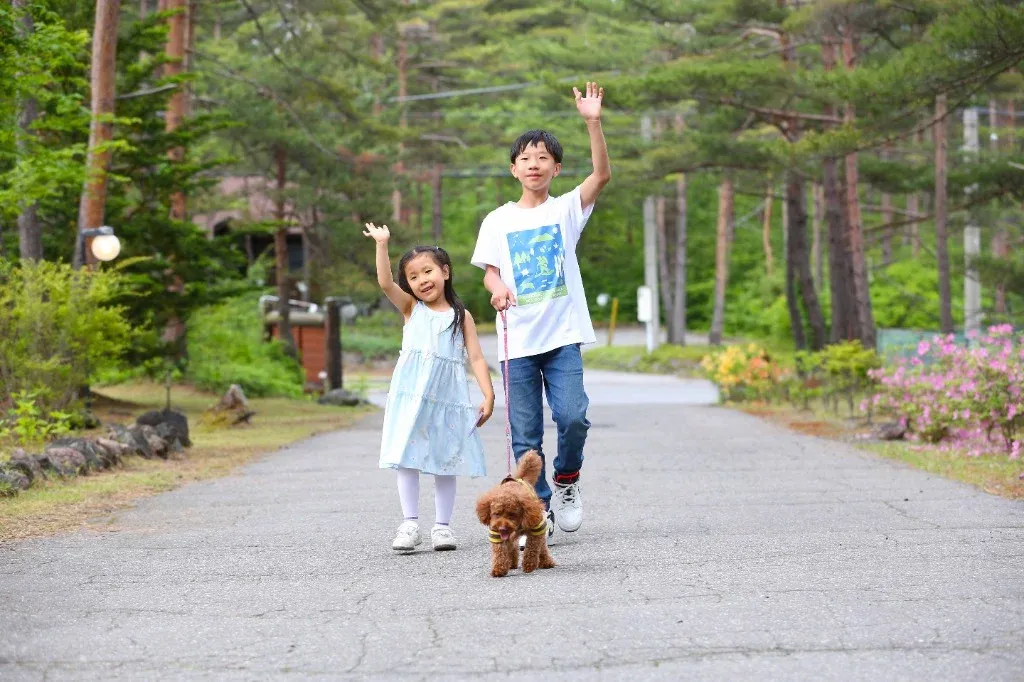 愛犬と一緒にお散歩をする子供たち