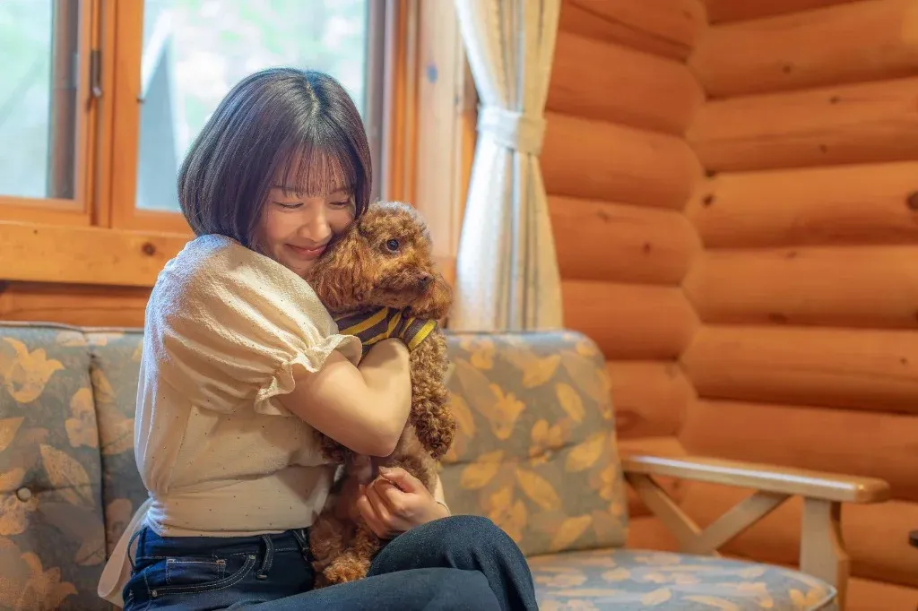 コテージで愛犬を抱きしめる